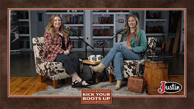 Taylor McAdams has blonde hair and is sitting next to Shelby Shank with red hair, looking at the camera, smiling, sitting, and having a conversation.